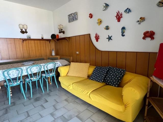 ein Wohnzimmer mit einem gelben Sofa und einem Tisch in der Unterkunft Liguria Holidays- La casa di Sara in Camogli