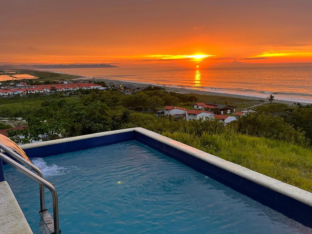 einen Pool mit Blick auf den Strand bei Sonnenuntergang in der Unterkunft Casa de Playa Koumpí Beach in Don Juan