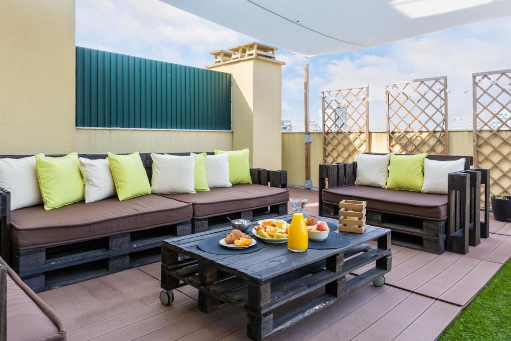 a patio with couches and a table with food on it at One Bedroom Apartment with Stunning River Views and Private Rooftop! in Lisbon