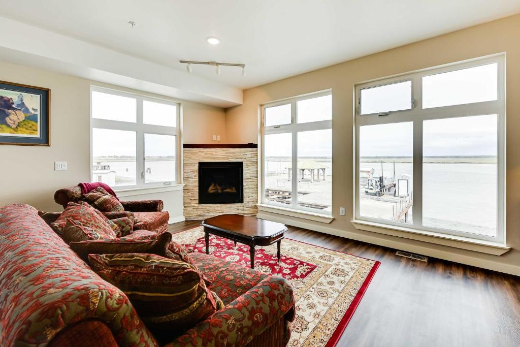 a living room with a couch and a fireplace at Waterfront Kenai Townhome Less Than 1 Mi to Beach! in Kenai