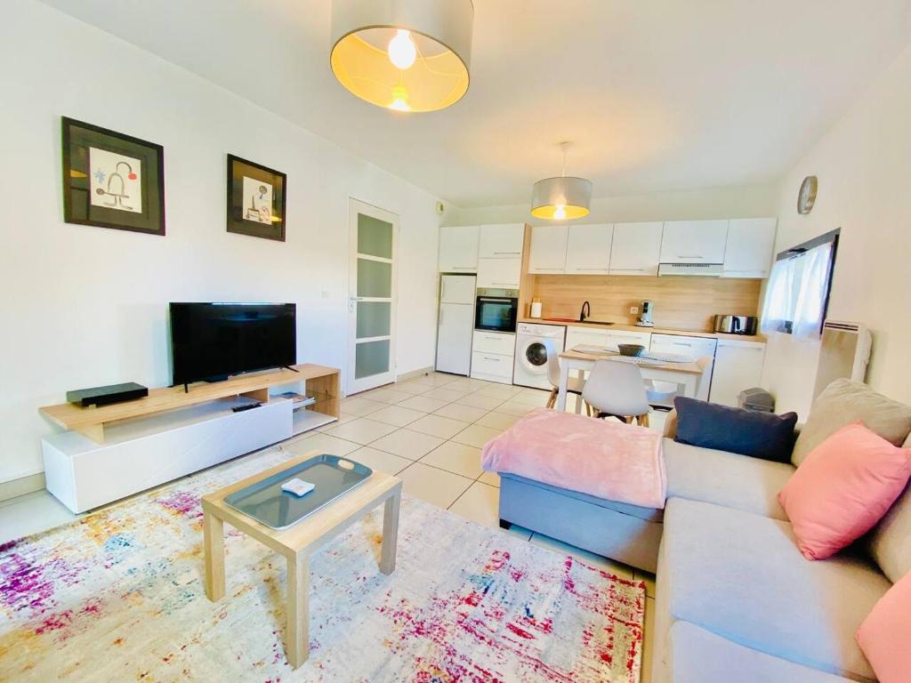 un salon avec un canapé et une table dans l'établissement APPARTEMENT 2 CHAMBRES AVEC BALCON ET PARKING, à Perpignan