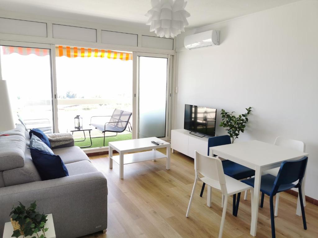un salon avec un canapé, une table et des chaises dans l'établissement Antibes studio Vauban dernier étage vue mer, à Antibes