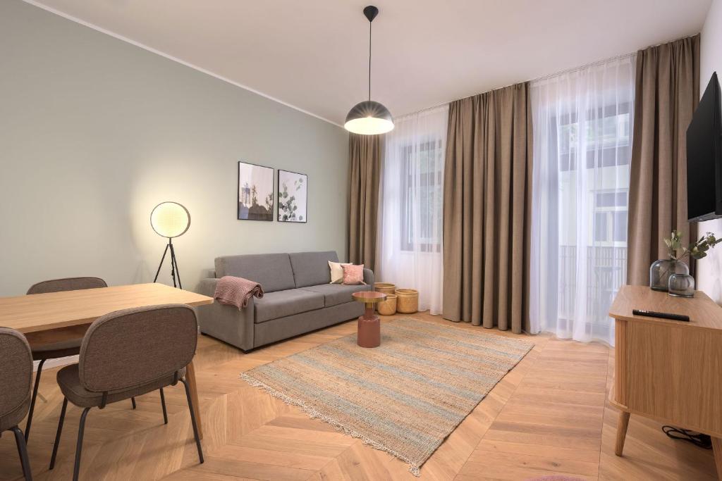 ein Wohnzimmer mit einem Sofa und einem Tisch in der Unterkunft limehome Vienna Karajangasse in Wien