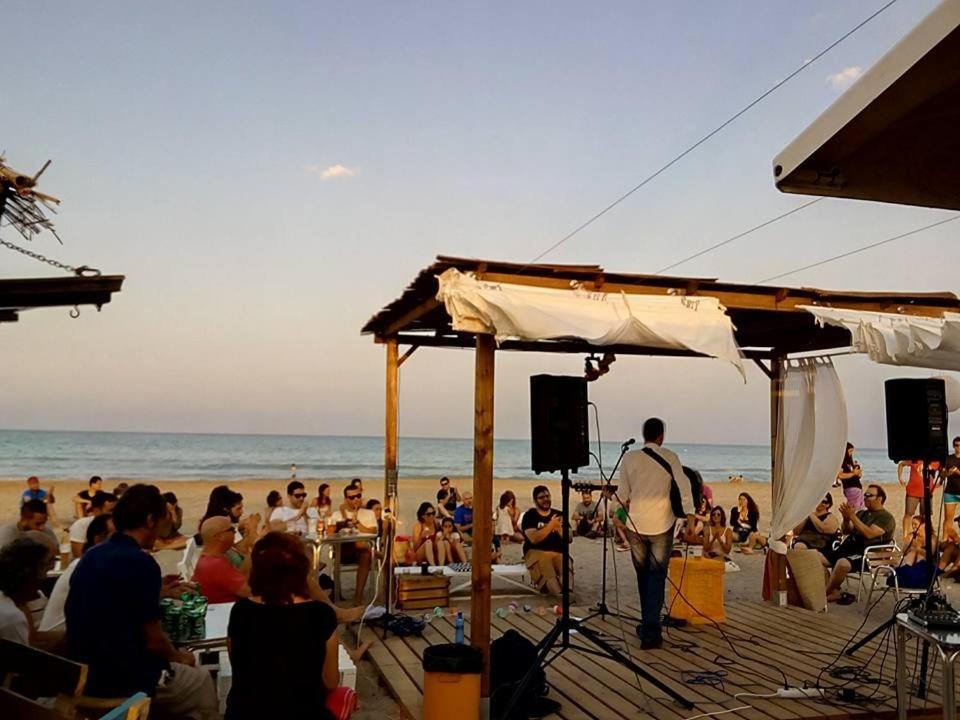 uma multidão de pessoas numa praia com um microfone em Chalet en playa de Almardá em Almarda