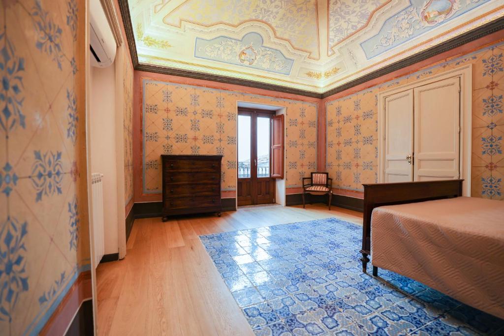 a bedroom with orange wallpaper and a bed in a room at Case Ruggieri Luxury apt - Don Pietro in Gratteri