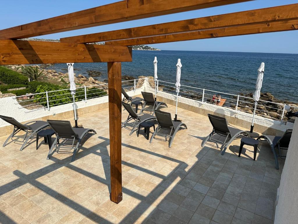 a group of chairs sitting on a patio next to the ocean at Salemarino apartment in Terrauzza