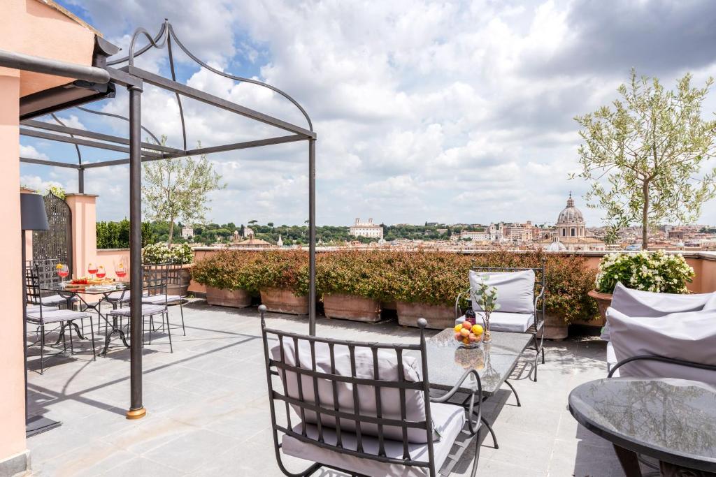 a patio with tables and chairs and a view of the city at The Best Rent - Spacious apartment with terraces with panoramic view of Rome in Rome