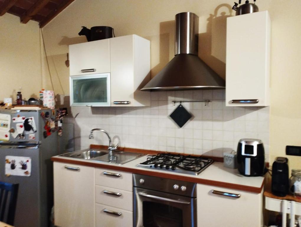 una cucina con piano cottura forno superiore accanto a un frigorifero di La casetta a Pieve a Nievole