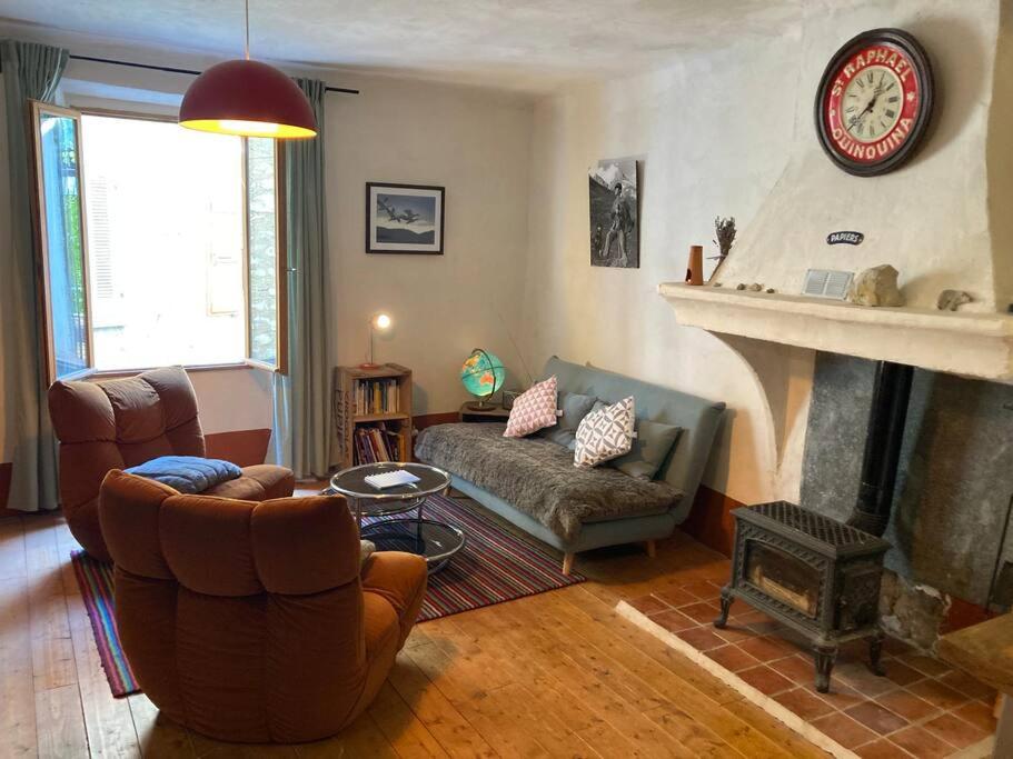 sala de estar con sofá y chimenea en Chez mamie Nénette, en Barrême