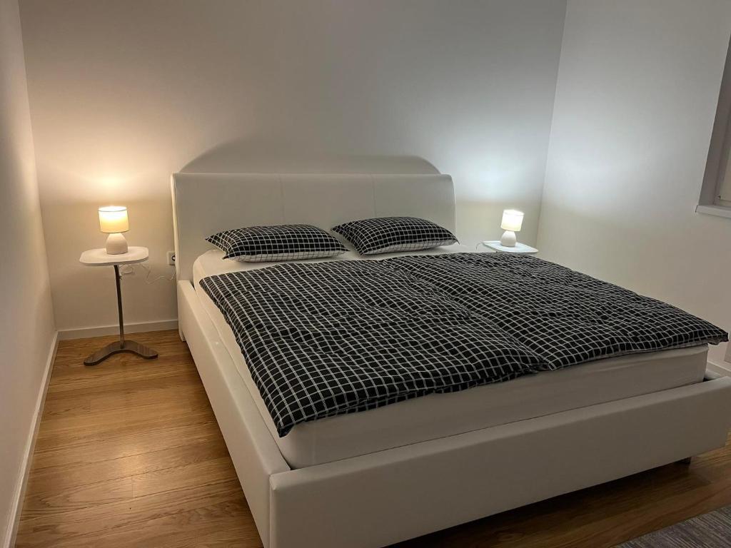 - une chambre avec un lit blanc et 2 lampes dans l'établissement Apartmani Behđetović, à Tuzla