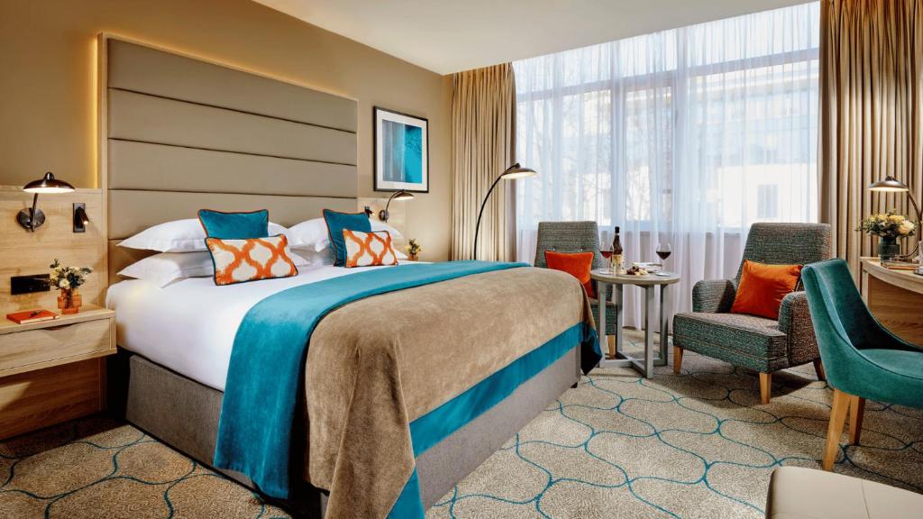 a hotel room with a bed and a desk and chairs at Mespil Hotel in Dublin