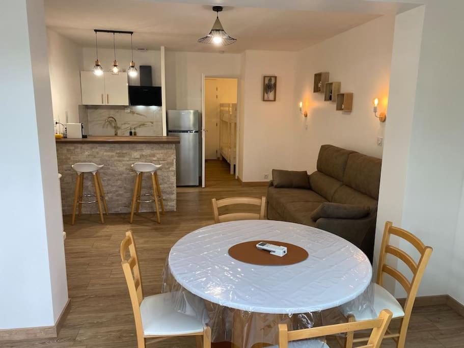 uma cozinha e uma sala de estar com mesa e cadeiras em Appartement résidence vacances amandier em Arles