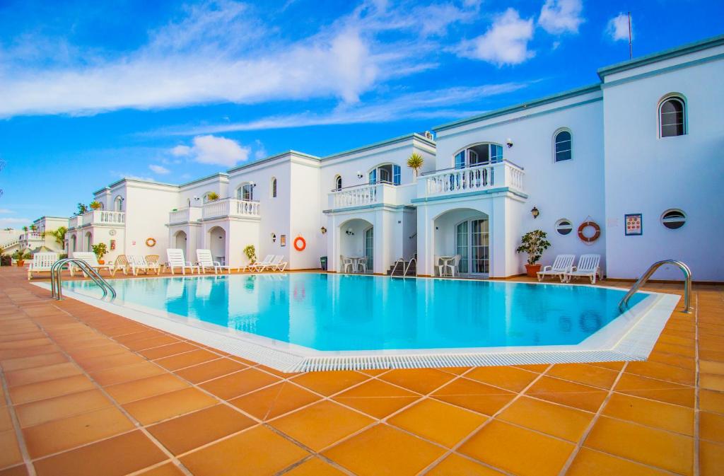 a large pool in the courtyard of a building at Apartamentos Corona Mar in Puerto del Carmen