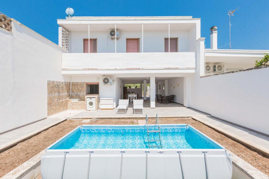 a villa with a swimming pool in front of a house at Villa delle Mimose by BarbarHouse in San Foca