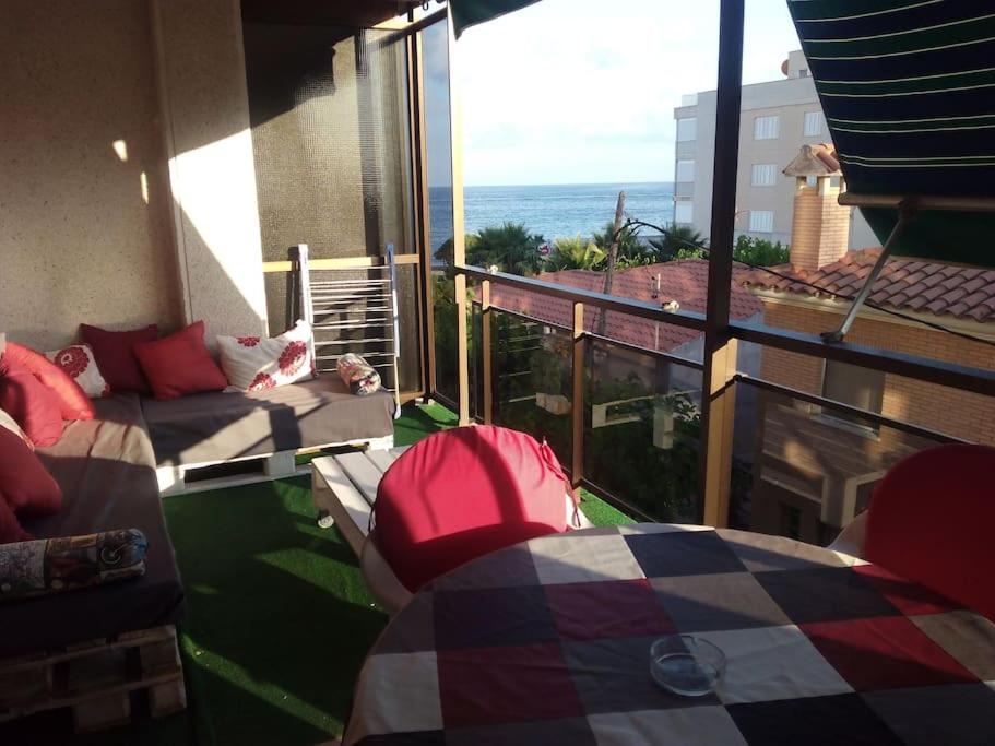 a balcony with a couch and a view of the ocean at Apartamento 1ª línea de playa!!! in Cambrils