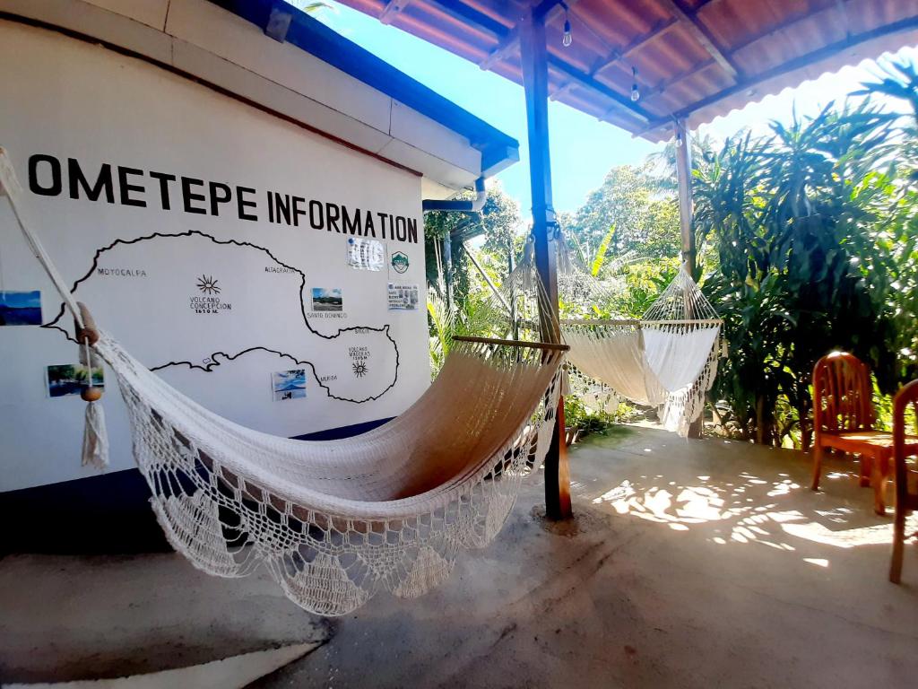 eine Hängematte vor einem Haus mit einem Schild darauf in der Unterkunft Casa de Gio in Moyogalpa
