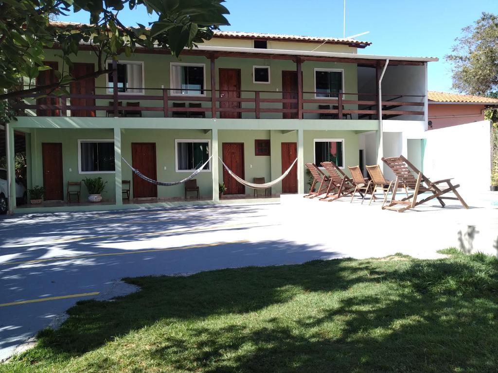 a house with rocking chairs in front of it at Estadia Cipó Pousada & Piscina in Serra do Cipo