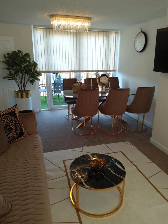 ein Wohnzimmer mit einem Sofa, einem Tisch und Stühlen in der Unterkunft Hill's View in Barnstaple