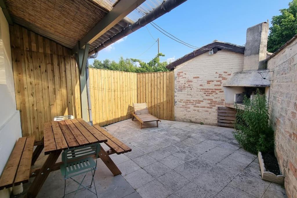 a patio with a wooden table and a wooden fence at Relaxing Holiday Home YHH in Lacanau