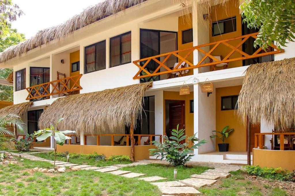 ein Gebäude mit Strohdächern und ein Resort in der Unterkunft Casa Yoo Bigu Mazunte in Mazunte