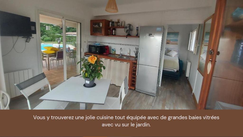 a kitchen with a table with a vase of flowers on it at Mignon petit appartement indépendant in Mérignac