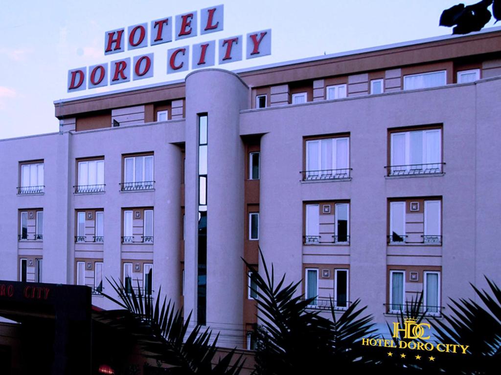 un cartello di una città dojo hotel sul lato di un edificio di Hotel Doro City a Tirana