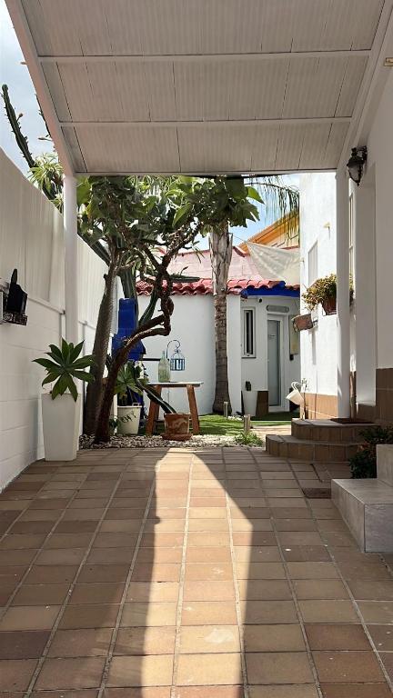 an outdoor patio with a white building and trees at Beach-Goretti House in Mairena del Aljarafe
