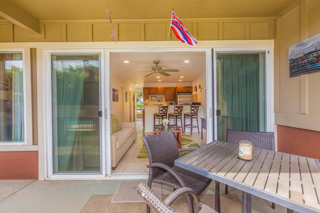 a screened in porch with a table and chairs at 2 Bedroom Kapaa Condo with Pool and AC 115 in Kapaa