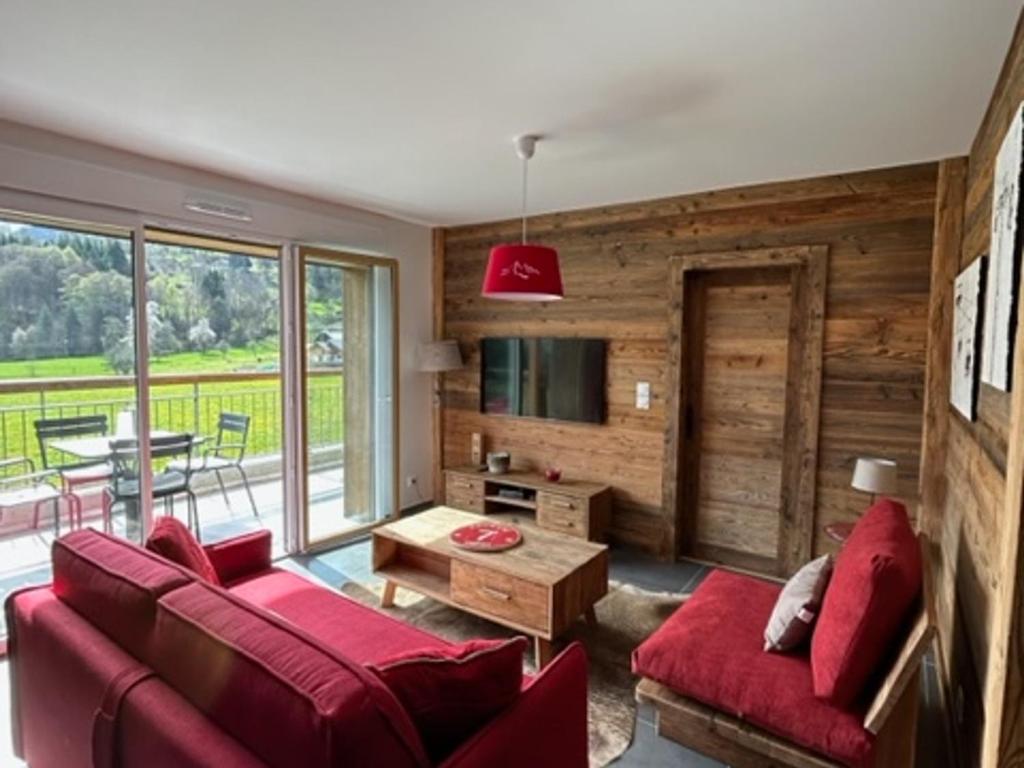 a living room with a red couch and a table at Appartement Samoëns, 3 pièces, 4 personnes - FR-1-624-97 in Samoëns