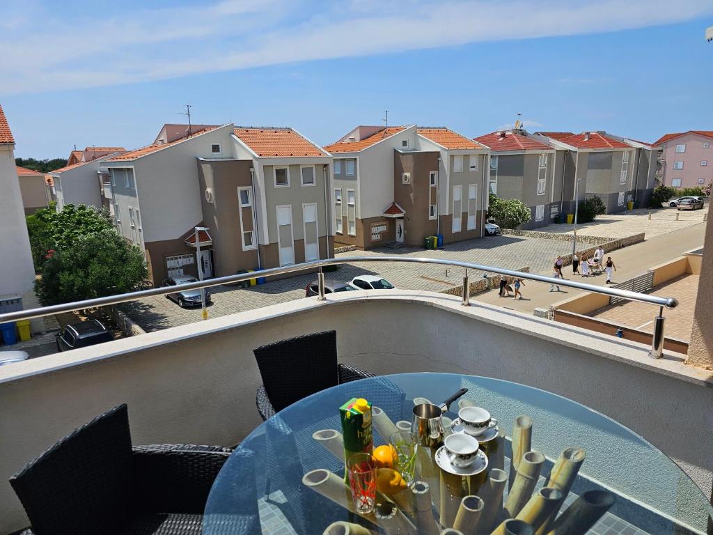 a table on a balcony with a view of buildings at SUNNY BALCONY TERRACE Apartment in Novalja