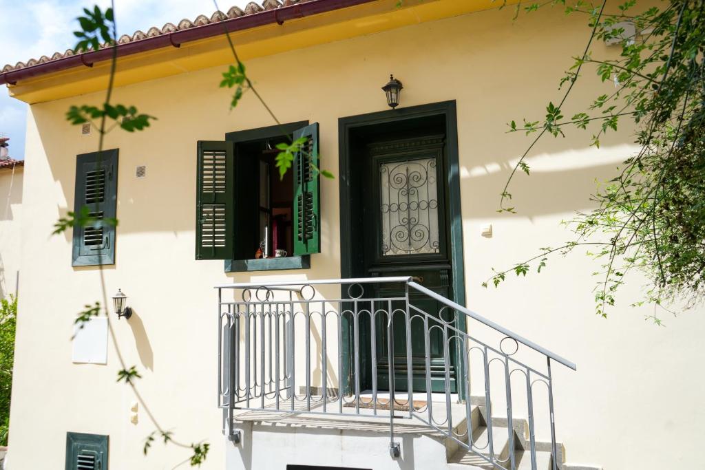 a house with a black door and a balcony at N1 Sokaki Apartment Nafplio in Nafplio