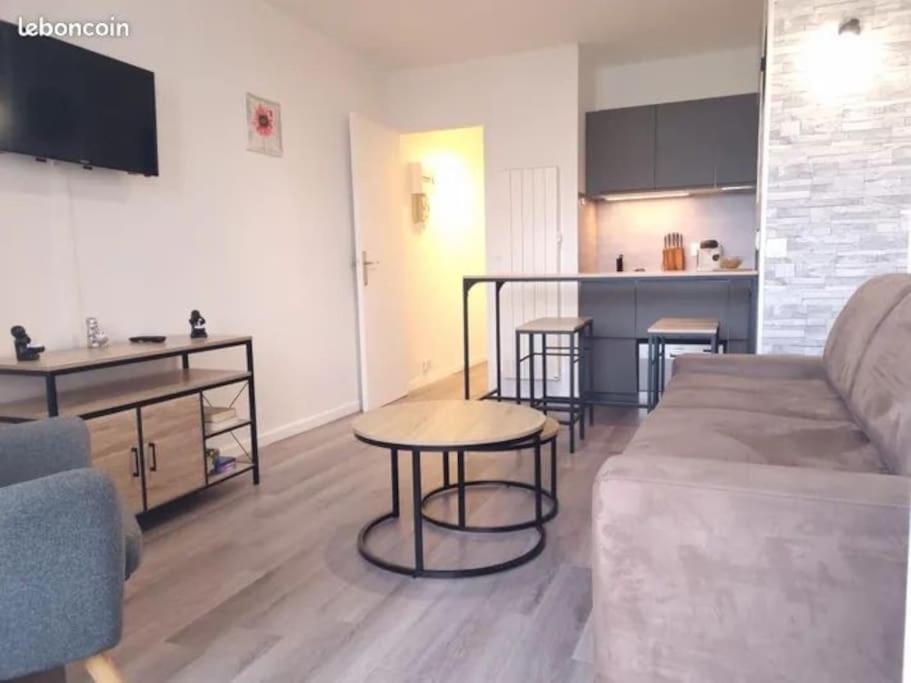 un salon avec un canapé et une table dans l'établissement Escapade en bord de mer : studio à la plage !, à Courseulles-sur-Mer