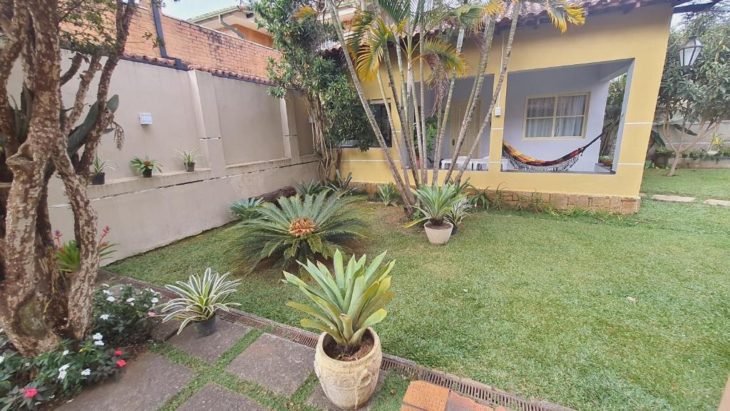 um quintal com vasos de plantas em frente a uma casa em SUA SUITE NA SERRA em Itaipava