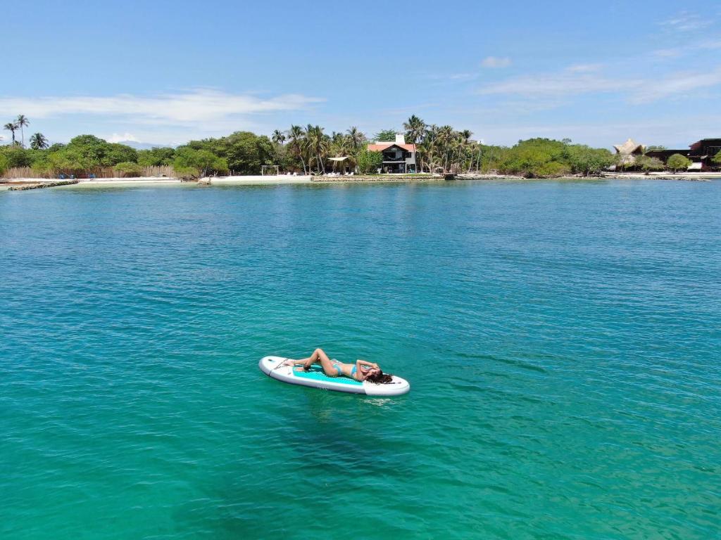 Tintipan Island的住宿－Sal Si Puedes，躺在水中桨板上的人