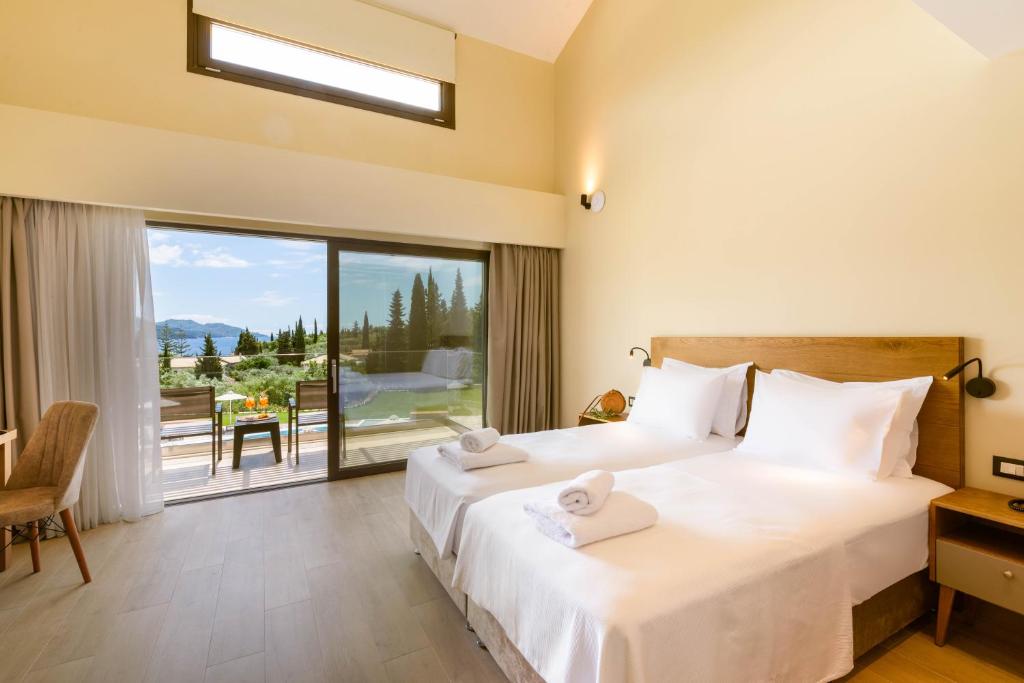 a bedroom with two beds and a large window at EPHYRA in Syvota