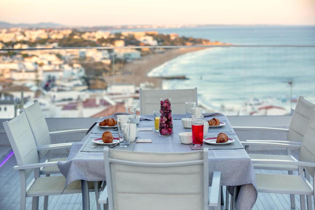 un tavolo con piatti di cibo e una vista sulla spiaggia di Infinito penthouse Luxury Best terrace Albufeira ad Albufeira