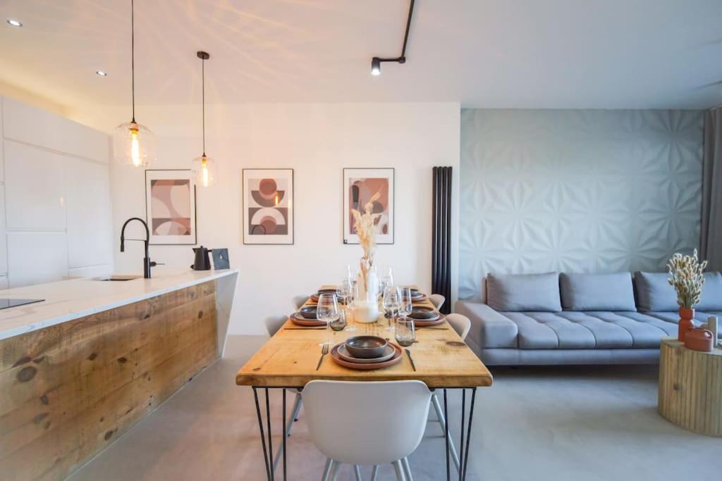 a kitchen and living room with a table and a couch at Nice 2 bedroom flat by The Heim Residences in Manchester