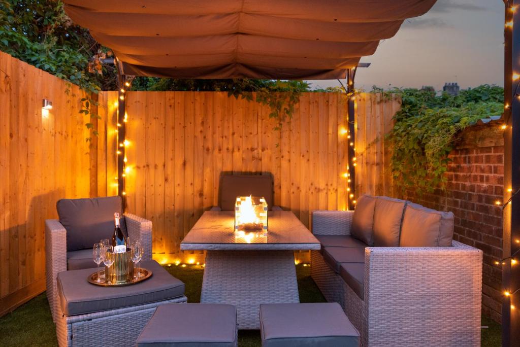 a patio with a table and chairs and lights at Exquisite Cardiff Apartments- with Garden Lounge & Games Room in Cardiff