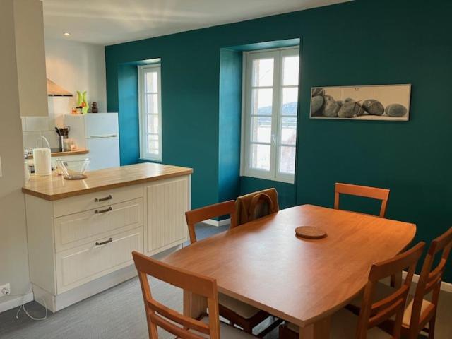 cocina con mesa de madera, mesa y sillas en Spacieux appartement pour 6 en Guérande