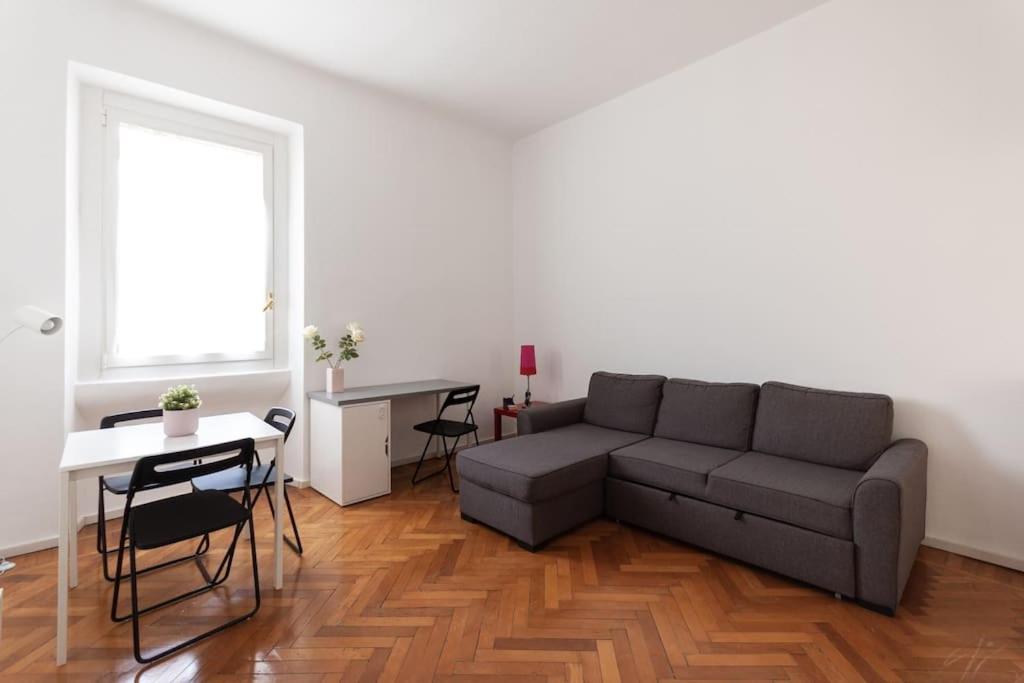 ein Wohnzimmer mit einem Sofa und einem Tisch in der Unterkunft YouHosty - Correggio 55 B in Mailand
