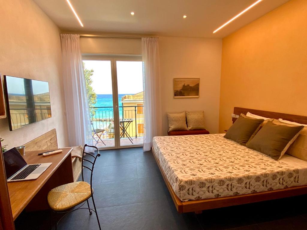 a bedroom with a bed and a desk and a window at Monterosso Rooms in Monterosso al Mare