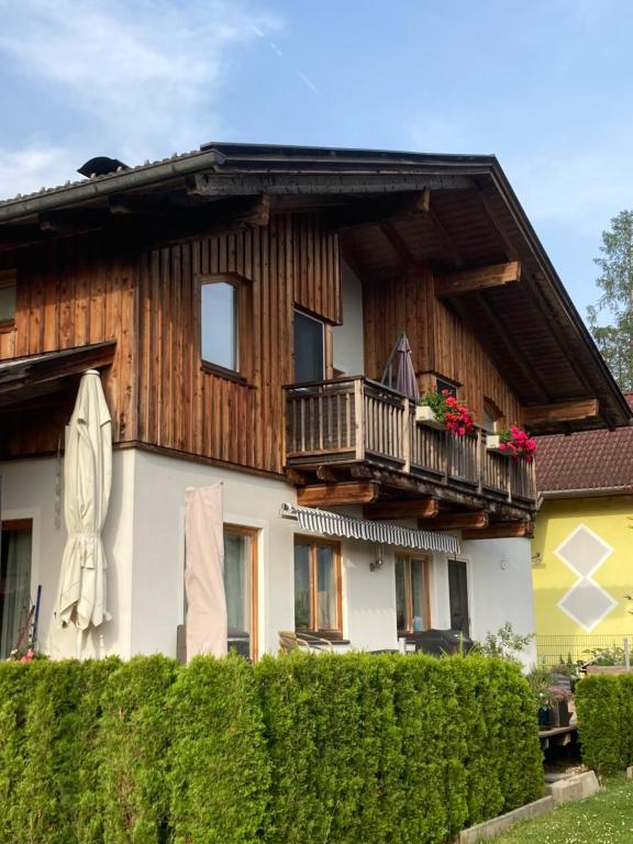 una casa con balcone e una donna sul balcone di Fewo Waldheim a Greifenburg