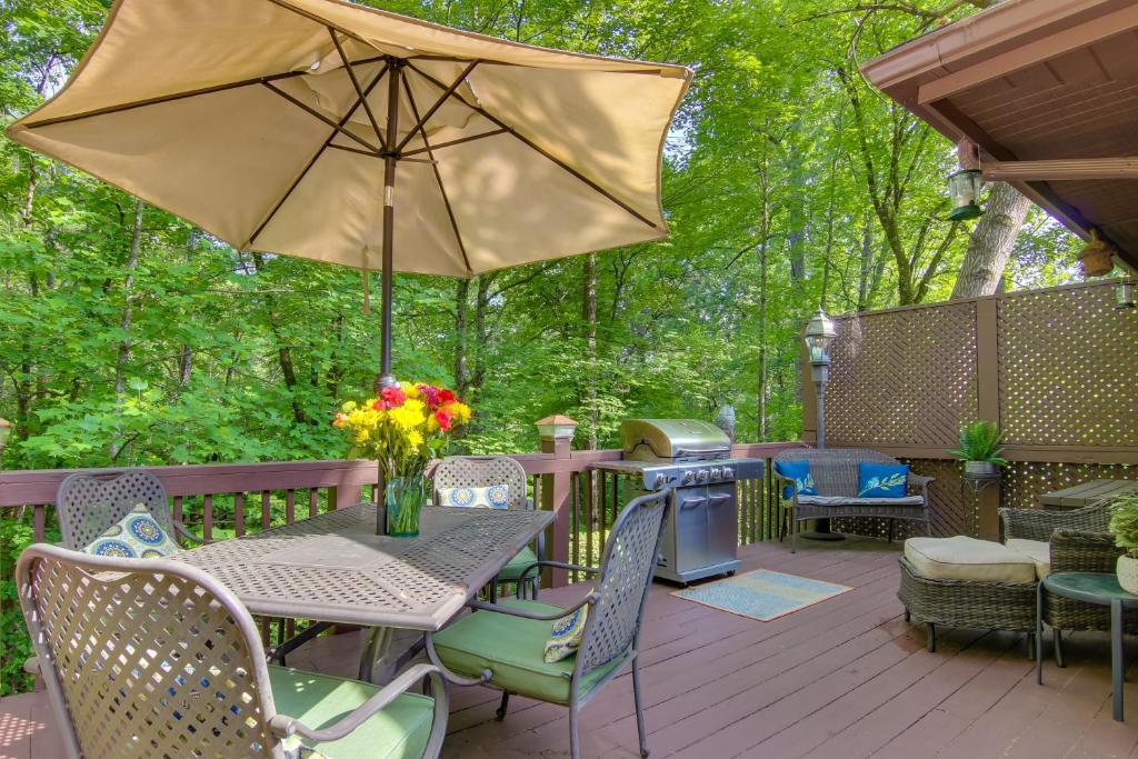 a patio with a table and chairs and an umbrella at Cabin in Lake Lure Near Chimney Rock and Asheville! in Lake Lure