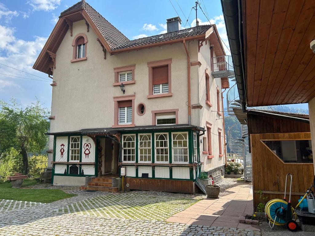 una casa grande con una gran puerta en un patio en 2 à 4 pers appartement dans Maisonnette piscine chambre double salle de bain privatif, en Saint-Amarin