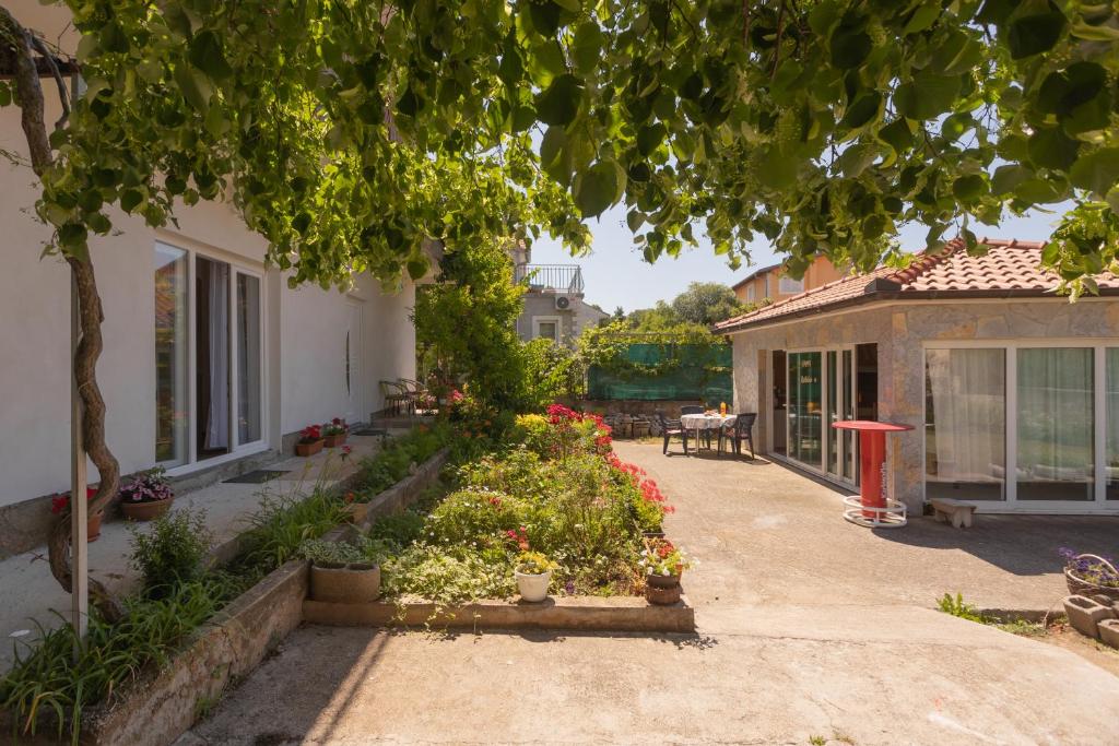 a house with a garden with flowers in the yard at Mara in Šibenik