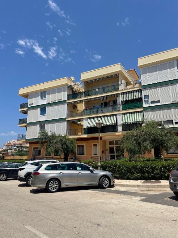 a parking lot with cars parked in front of a building at Piso con parking y piscina en Torrox costa in Torrox Costa