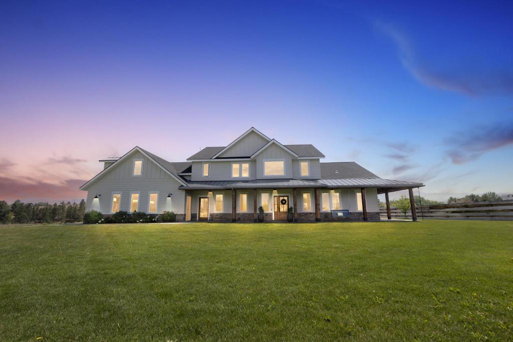 a large white house with a large grass field at Three Bears Get Away farmhouse in Hamilton