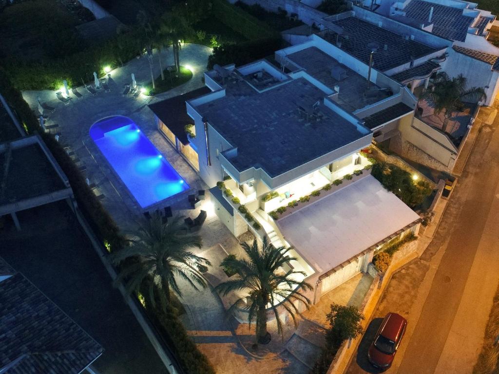 una vista sul tetto di una casa con piscina di notte di b&b Villa Grazia a Leverano