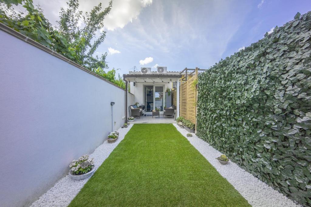 a backyard with a green lawn and a fence at Sun&Garden Flat in Cagliari