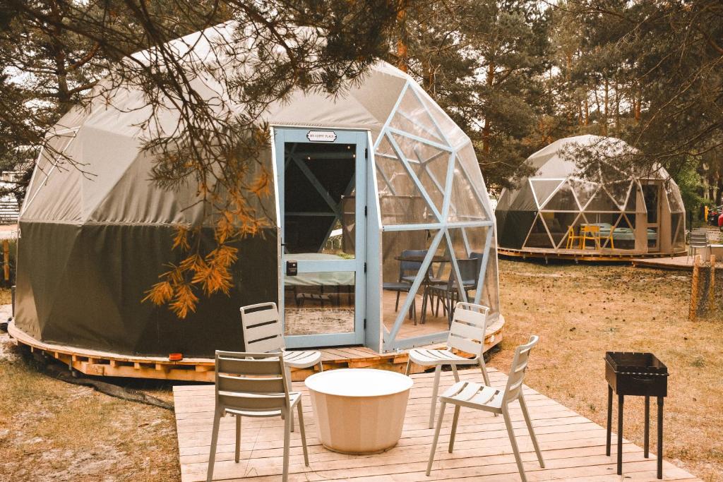 una yurta con sedie, tavoli, tavolo e sedie di Čiki Puki Glamping a Palanga